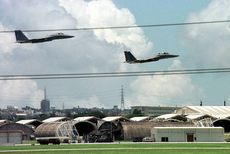 美軍F-15戰機於日本沖繩嘉手納基地上空飛行，前方可見用於保護戰機的機堡（掩體）設施。日媒引述分析指出，中國疑在沙漠模擬類似結構進行相關測試。（美聯社檔案照）