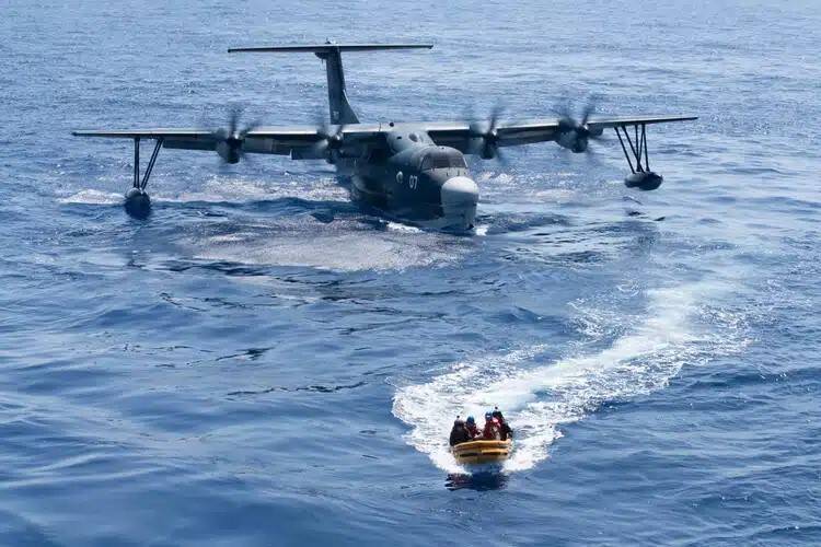 日本海上自衛隊US-2水陸兩棲救難飛行艇降落於南海海面，與美軍阿希蘭號派出的小艇進行傷患接駁演練。（圖取自美國印太司令部）
