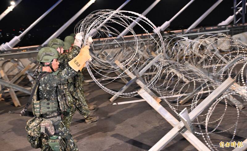 國軍官兵在漢光42號演習期間，在淡江大橋架設鋼刺蝟。（資料照）