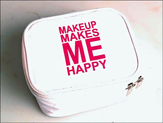 張榕容的化妝品就裝在這個「化妝使我快樂」的化妝包裡。（記者陳奕全攝）