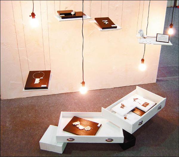 新一代設計展的瑞典展區裡，陳禹潔以抽屜來展示精工創作，搭配燈泡和懸掛的層架，在偌大的展場中非常吸「睛」。