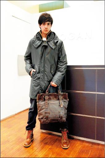 紀亞文穿Hogan著名的風衣，強調腰身的設計穿來時尚。手拿Shopping Militare托特包，腳踩新推的Route 1半筒靴。