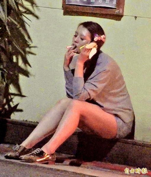 與友人聚會時,劉品言不時在餐廳門口抽菸、講電話,蹲坐在牆角時大腿顯得更「粗壯」。(專案組攝) 與友人聚會時,劉品言不時在餐廳門口抽菸、講電話,蹲坐在牆角時大腿顯得更「粗壯」。(專案組攝)