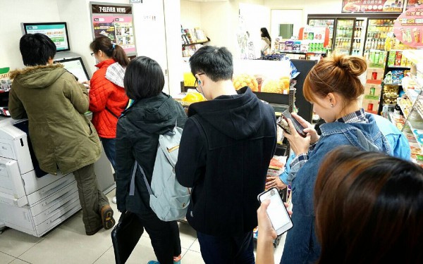 江蕙演唱會今天中午12點開賣,粉絲在超商購票機邊排隊邊用手機上網搶票,但排第一組的粉絲過了20分鐘仍未成功買到票 。〔記者陳奕全攝〕 江蕙演唱會今天中午12點開賣,粉絲在超商購票機邊排隊邊用手機上網搶票,但排第一組的粉絲過了20分鐘仍未成功買到票 。〔記者陳奕全攝〕