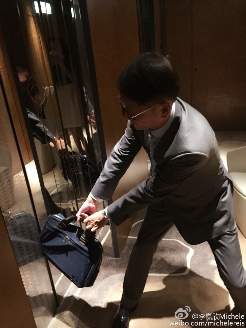 許晉亨公事包背被電梯夾住，拚命想拉開。（取自微博）