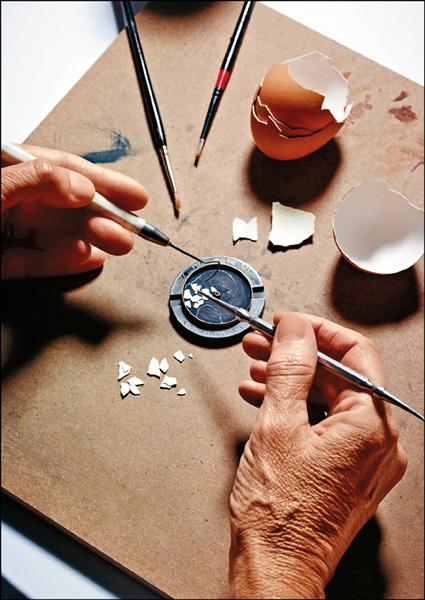 藝匠正在切割和鑲嵌蛋殼碎片，準備砌合雄鷹。