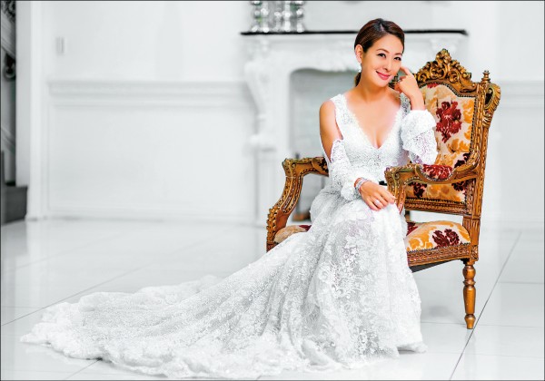 白色婚紗好像正在祝福賈永婕結婚14週年紀念，衣服的卡肩、荷葉邊設計別出心裁。搭配寶格麗Serpenti鑽戒756,000元、耳環742,000元、手環2,126,000元、密鑲鑽石戒指269,000元。