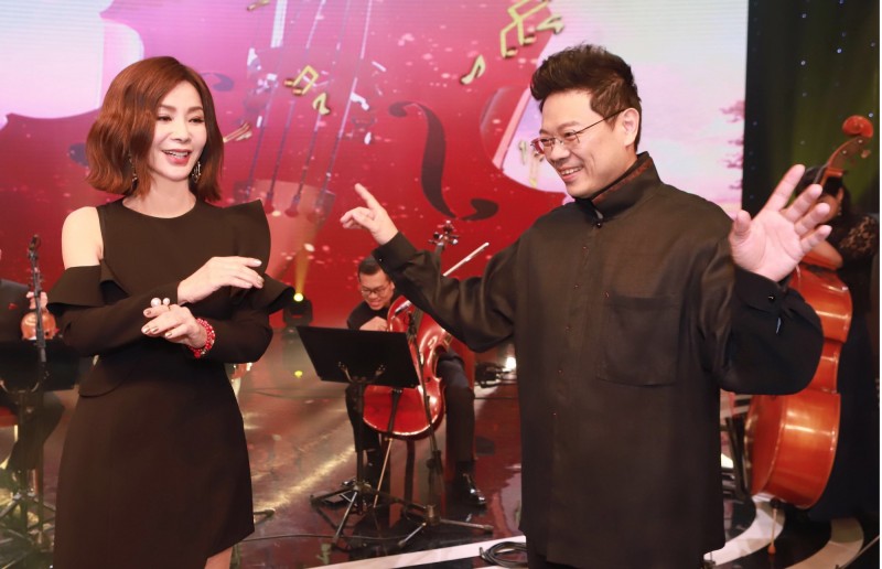 陳美鳳（左）為節目挑戰擔任指揮，向主持人李哲藝討教。（民視提供）