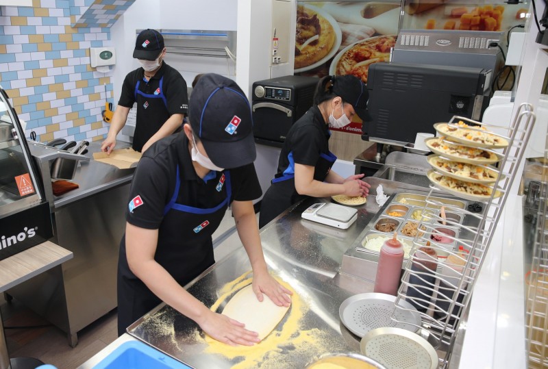 7-ELEVEN與達美樂共同打造全球最迷你的手作現烤披薩生產線，消費者點餐後，現場從拍麵、放上新鮮餡料、進烤箱快速烘烤，製作流程與既有達美樂相同，美味絲毫不打折。（7-ELEVEN提供）
