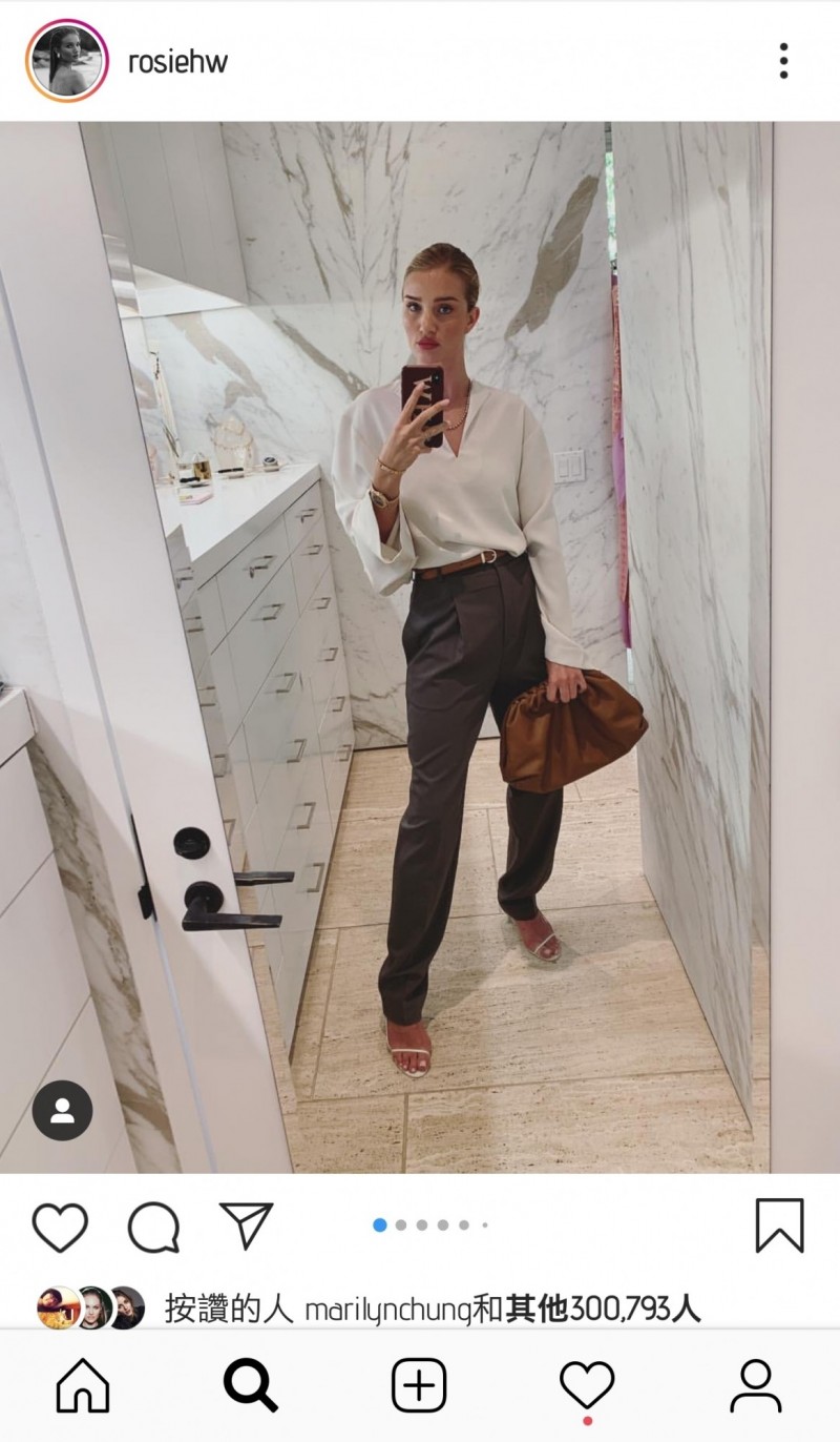 週一：蘿西．杭汀頓．懷莉以誇張袖攏的上衣搭配打折西裝褲與高跟涼鞋，手抓Bottega Veneta The Pouch手拿包，展現時髦OL裝扮。（翻攝自IG@rosiehw）