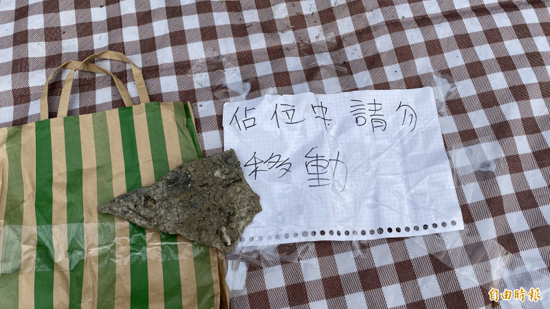 新營南瀛跨年晚會舞台前出現野餐墊和紙板占位子，放上「請勿移動」、「占位中」、「動了就殺去你家拔河」的紙條。（記者楊金城攝）