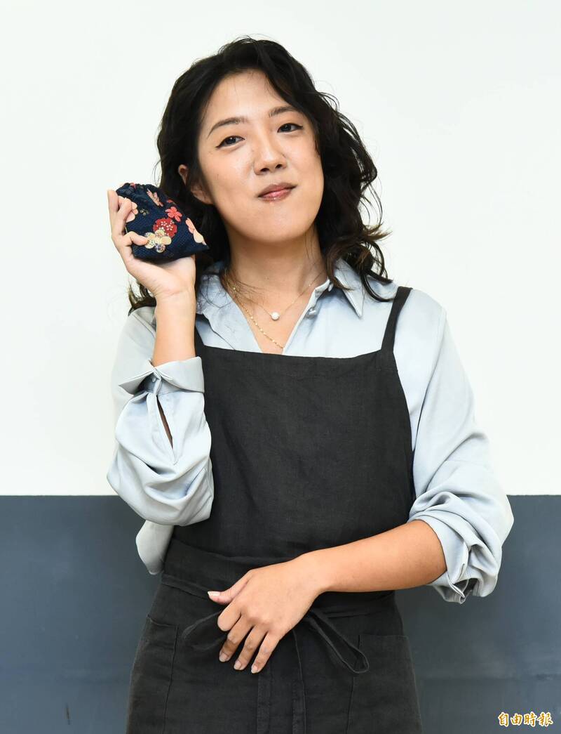 李竺芯手拿舍利子。（記者陳奕全攝）