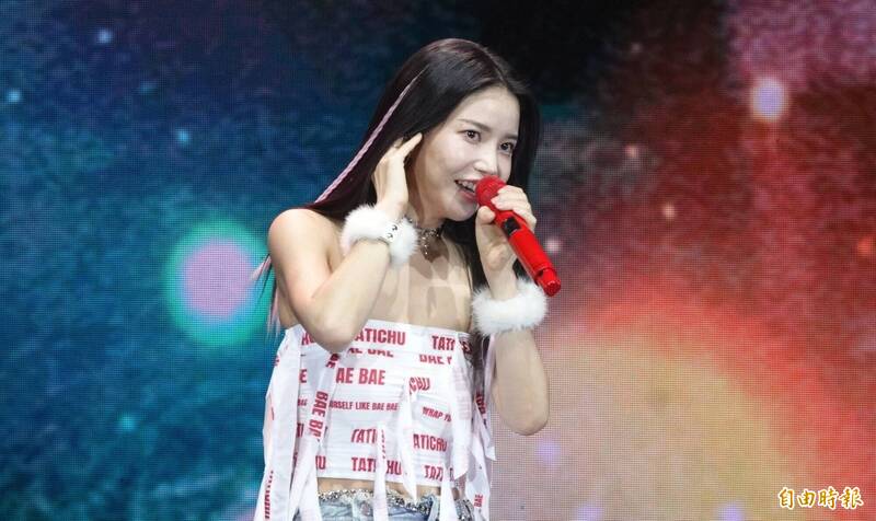 頌樂右手放在耳朵，左手拿紅色麥克風。（記者潘少棠攝）