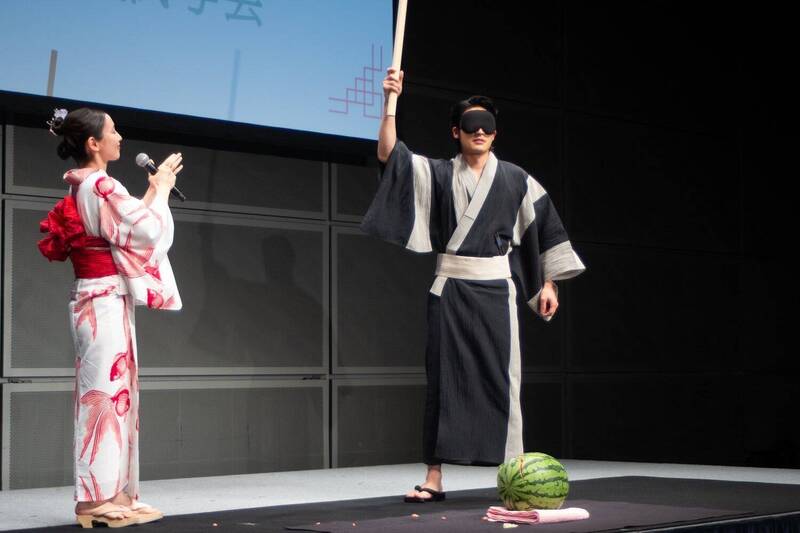 水上恒司（右）蒙眼進行切西瓜儀式，吉岡里帆在一旁指示方向。（翻攝自X）