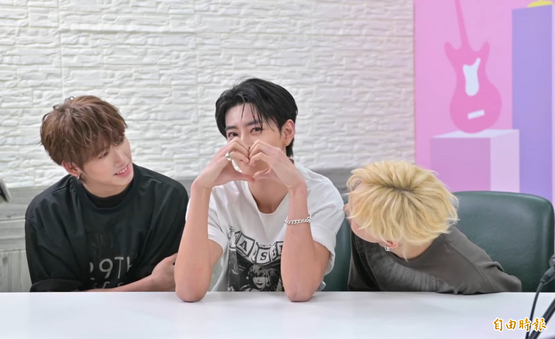 义翔（左）、帝翁（右）認真的看學駿比愛心放電。（記者胡如虹攝）