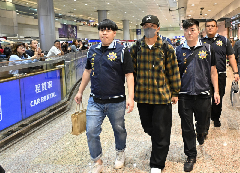 坤達一下機，即遭檢警拘提帶回偵訊。（記者劉信德攝）