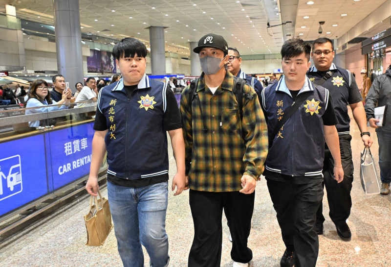 坤達一下機，即遭檢警拘提帶回偵訊。（記者劉信德攝）
