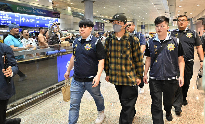 坤達一下機，即遭檢警拘提帶回偵訊。（記者劉信德攝）