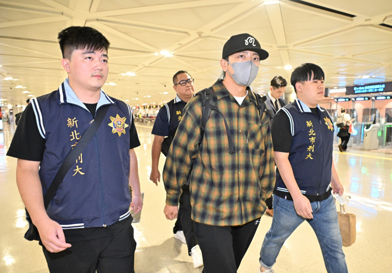 坤達一下機，即遭檢警拘提帶回偵訊。（記者劉信德攝）