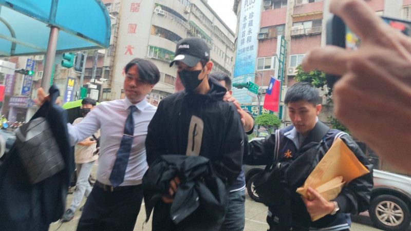 檢警昨將修杰楷拘提上銬帶回偵辦。（記者陸運鋒攝）