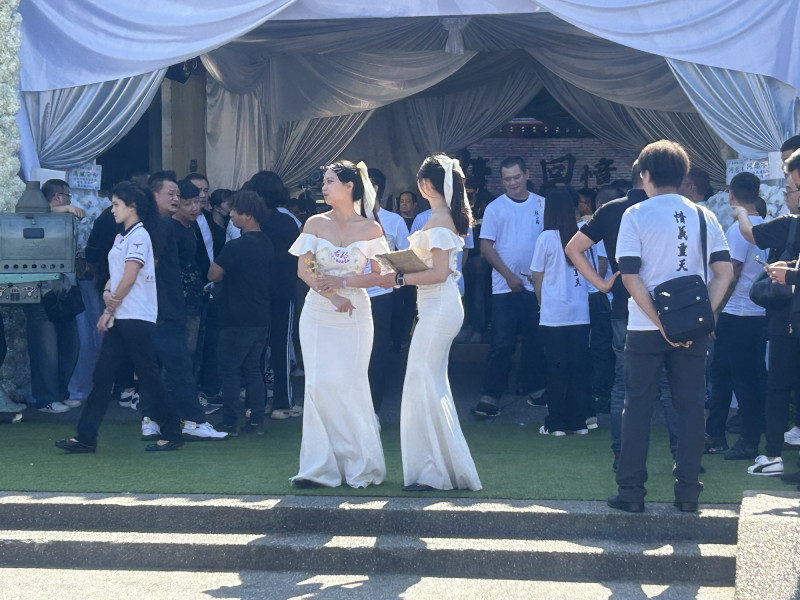 顏正國告別式登場，禮生在會場進出，一旁男子身穿「情義重天」T恤現身。（記者廖俐惠攝）