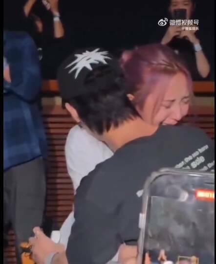 Nene（後）在見面會上抱著男友Bright痛哭。（翻攝自微博）