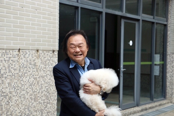 王世堅自稱貓奴，卻還是被小白狗萌得投降。（台北海大提供）