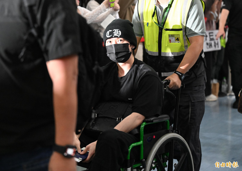 AAA小港機場接機，Stray Kids的Lee Know坐在輪椅現身。（記者李惠洲攝）