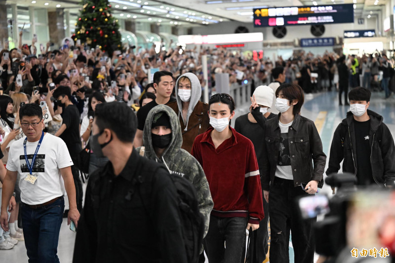 AAA小港機場接機，CORTIS的趙雨凡身穿迷彩服、戴黑口罩，走在隊伍最前方。（記者李惠洲攝）