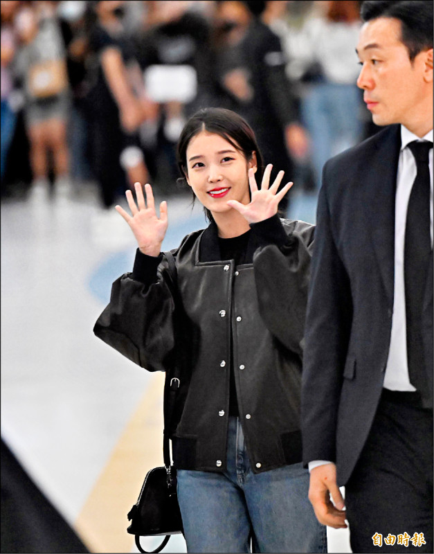 IU昨天現身小港機場，熱情與粉絲揮手。（記者李惠洲攝）