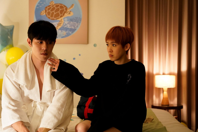 孫可芳（右）在《何百芮的地獄戀曲》與「性感浴袍男」詹懷雲（左）開房間。（彼此影業提供）