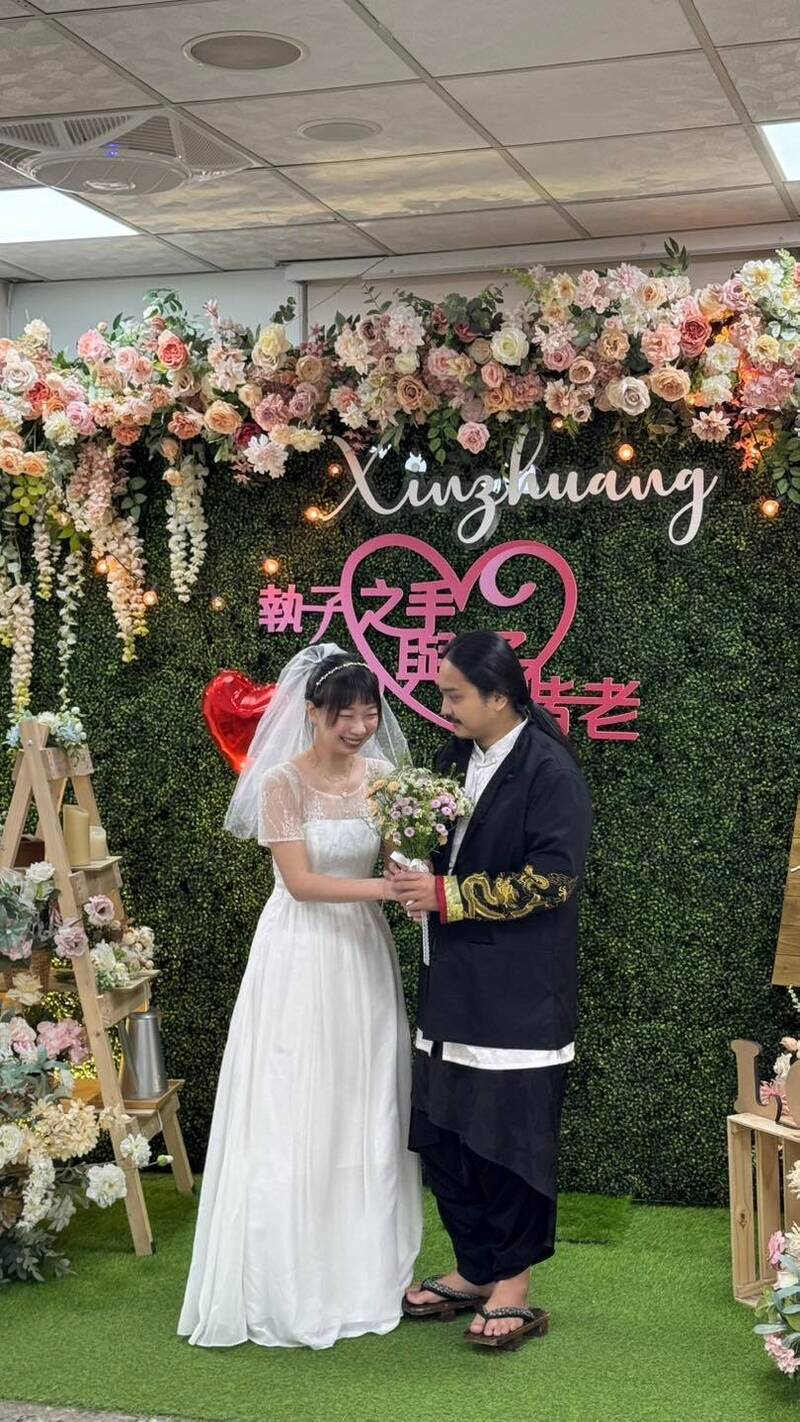 幻術大仙（右）穿著表演服裝搭配招牌木屐，身旁是穿著簡單白紗的新娘子。（翻攝自臉書）