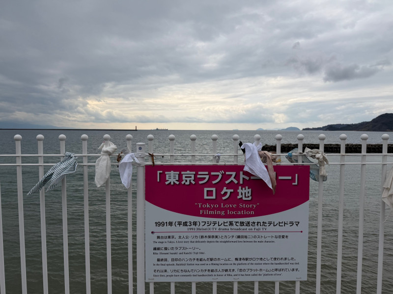 「梅津寺」車站月台上看板介紹當年《東京愛情故事》曾到此取景拍攝。（記者陳慧玲攝）