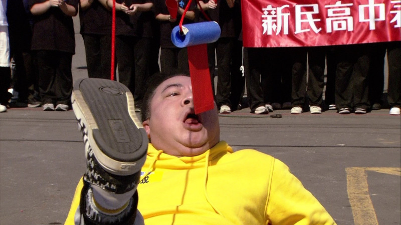董至成上場代打，仰頭張口精準咬住紅包。（民視提供）