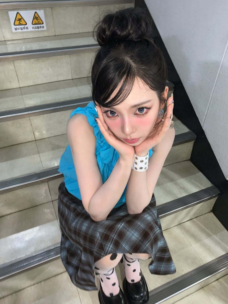 Karina曬出自己綁著丸子頭造型，穿著藍色無袖上衣搭配短紋格裙系列美照。（翻攝自IG）