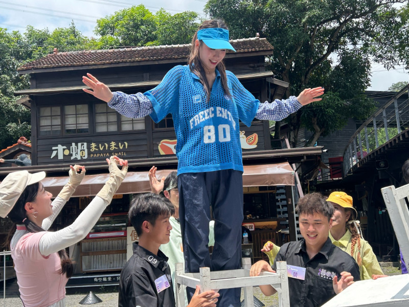 李雅英硬著頭皮挑戰椅子疊羅漢，張開雙手努力穩住重心。（民視提供）