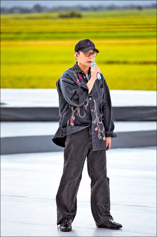 台東の稲田を背に、池上の野外舞台でマイクを持つ張信哲