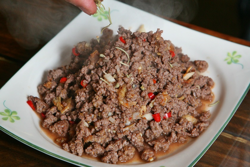 牛肉盛盤後，撒上迷迭香。先將春捲皮沾點水至軟化，再擺上生菜、小黃瓜片以及放涼後的牛肉一起捲起食用，別具風味。