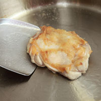 起油鍋，將雞腿肉煎至雙面略呈金黃色約三至四分鐘。