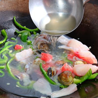 熱鍋，加入1匙沙拉油、蒜末爆香，放入青椒炒至表皮油亮，續加入蝦、魚、透抽、肉片、蛤蜊拌炒，倒入米酒、雞高湯，加熱至滾。