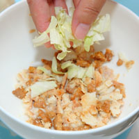 瀝乾牛奶留下吐司邊後，加入高麗菜絲、紅蘿蔔丁、中筋麵粉和鹽，拌勻成為麵糊。