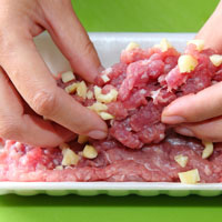 蒜頭切末。將蒜末放入絞肉內，加醬油和味醂調味、抓勻。


