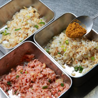 將炒好的炒飯分3份，其中2份分別加入紅麴醬、咖哩粉後拌勻。接著依序將咖哩、原味、紅麴炒飯分別裝入塔模後壓緊，再倒扣於盤中，即完成。
