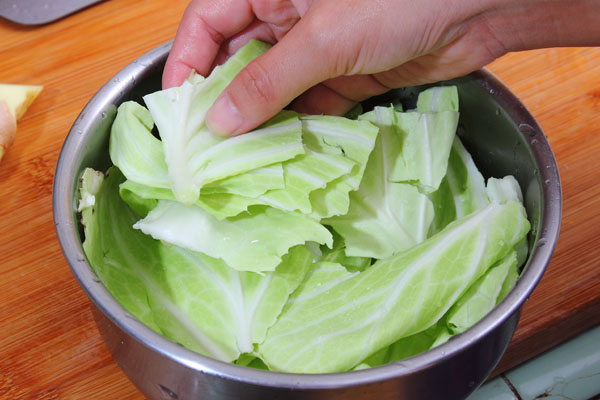 將高麗菜洗淨後剝成一片一片，另取一鍋放入鋪底，再依序放入牛筋、紅蘿蔔塊、薑片、米酒、鹽巴。