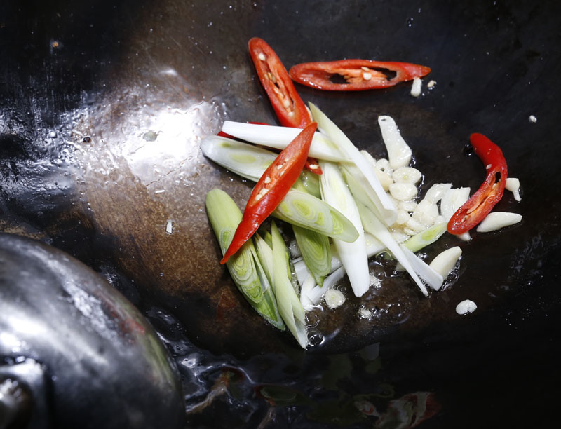 同油鍋，蒜苗、辣椒與蒜仁下鍋爆香後，放入香腸、米酒、醬油、糖、少許水快速翻炒，起鍋前淋上香油即可上桌。
