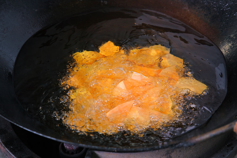 紅地瓜洗淨去皮切成小塊，放入中火160℃的油鍋油炸，油量約500c.c.，期間要不停攪拌避免地瓜焦掉，約4到5分鐘，撈起瀝乾油，靜置備用。