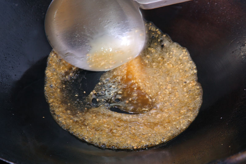 利用步驟1瀝完油的鍋子中殘留的油分炒糖，點小火放入白砂糖以及開水100g，溶化後的白砂糖要一直不停翻炒，約4分鐘等砂糖變成淺咖啡色即完成。