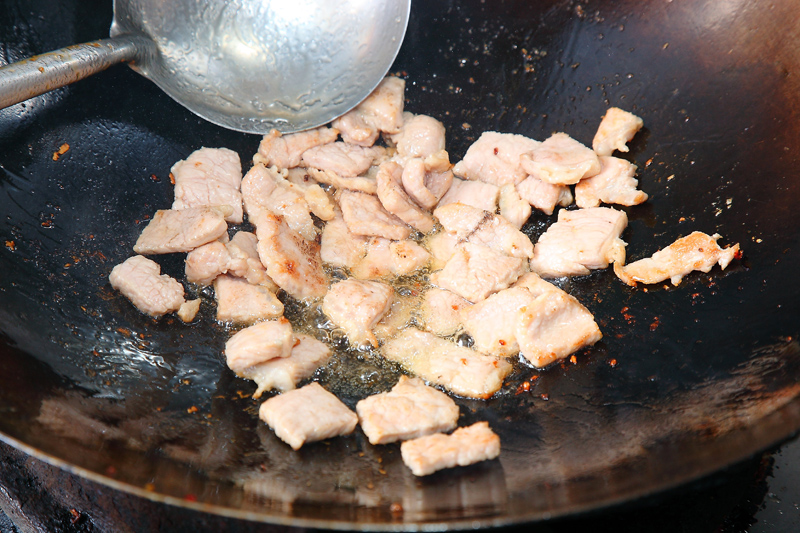 起一熱鍋，油溫約160℃，將豬肉片煎至兩面金黃色。