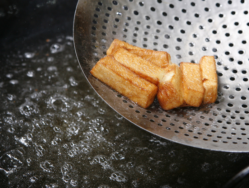 豆腐條下鍋油炸，油溫80∼90℃，炸至表面呈金黃色即可撈起備用。