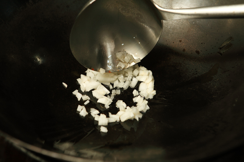 洋蔥、蟹腳肉切小丁。起鍋開大火，加入適當油量，待油鍋開始冒煙時，加入洋蔥拌炒出香味，再放蟹黃、鹽、白糖拌炒約20秒。